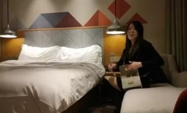 Hindi pinahihintulutan ang paninigarilyo sa isang batang mature na babae na naka-itim na bota at isang palda sa balakang.